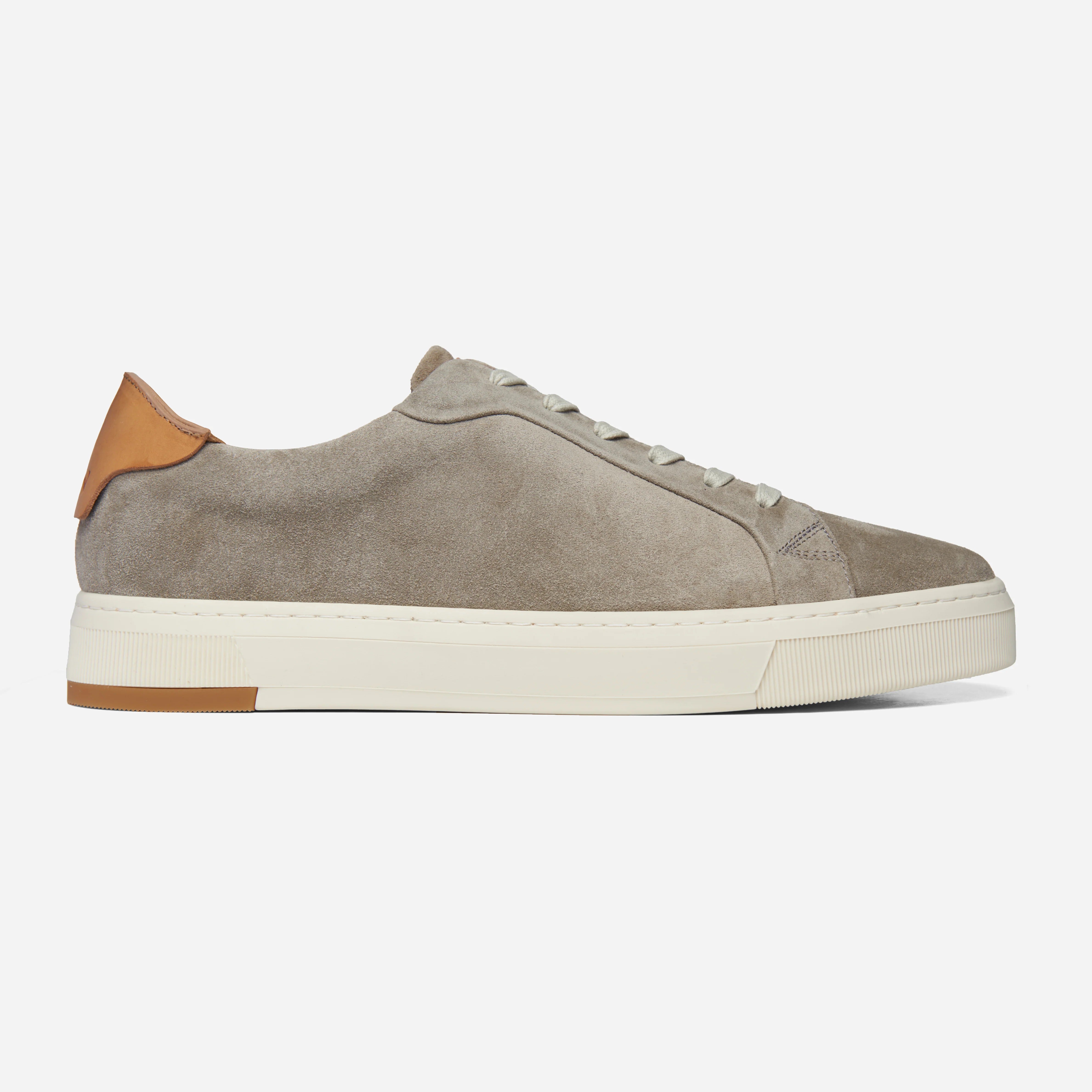 Gray suede sneaker with brown accents on a white background