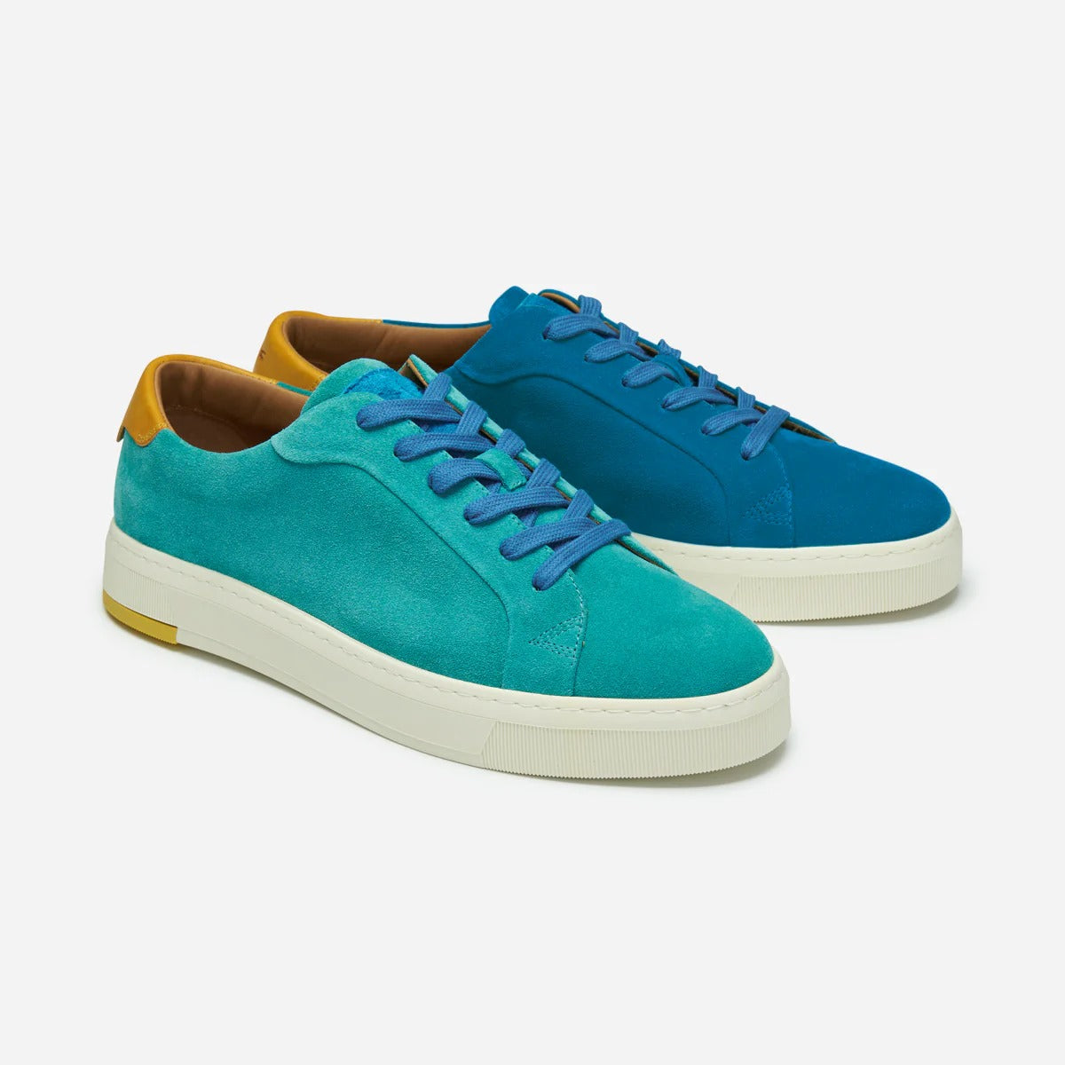 Blue and turquoise sneakers with white soles on a light gray background