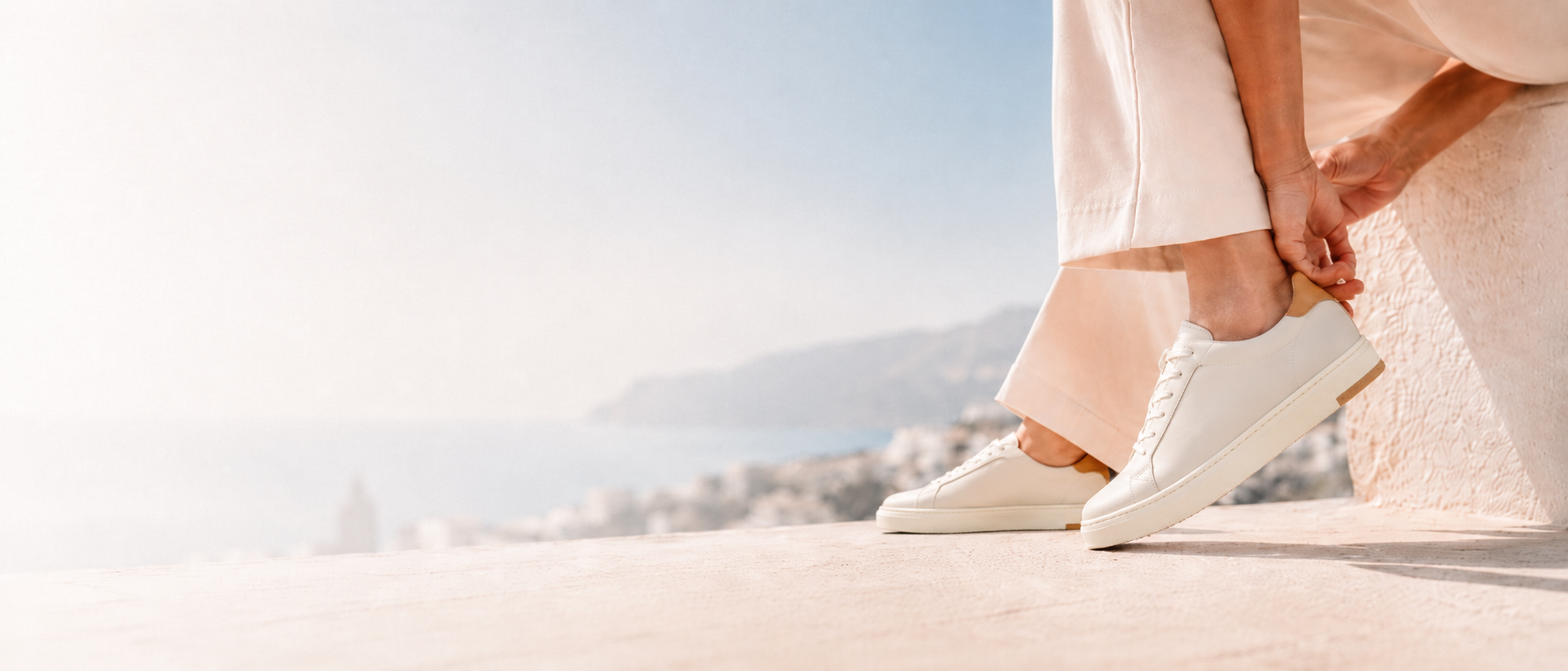 VYN Long Luxe white leather sneaker worn with a light summer outfit